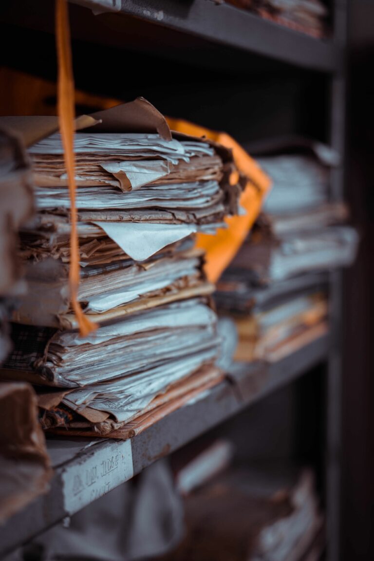 Stacks of old documents and papers piled on dusty shelves, creating an organized yet chaotic scene.